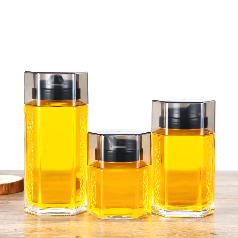 High grade thickened 180ml-500ml double-sided embossed hexagonal glass honey jars with plastic dispenser