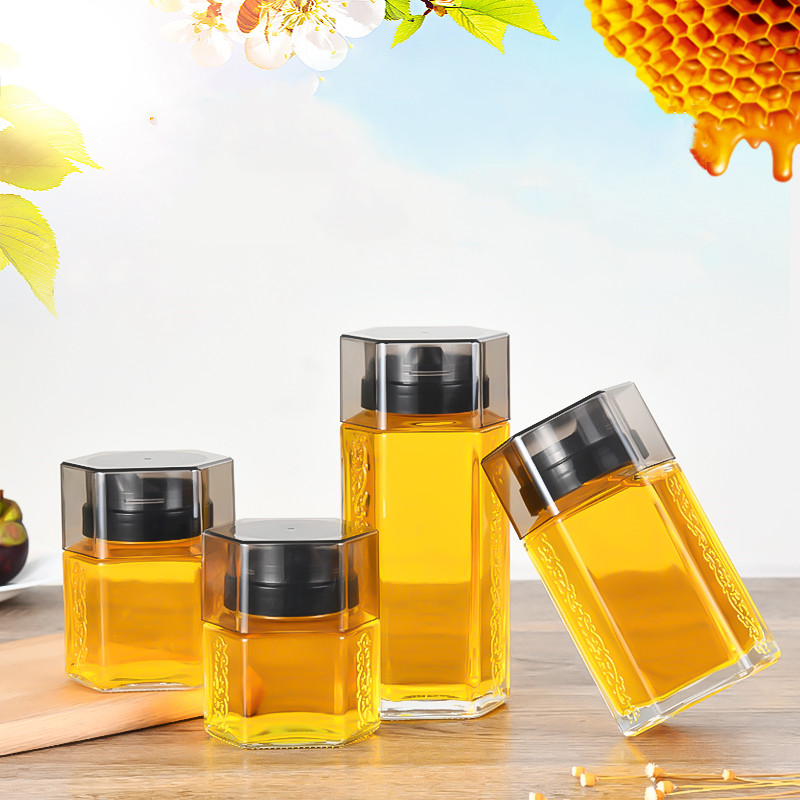 High grade thickened 180ml-500ml double-sided embossed hexagonal glass honey jars with plastic dispenser