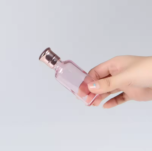 Customized color 30ml 50ml 100ml clear pink essential oil glass bottle with rose golden cap