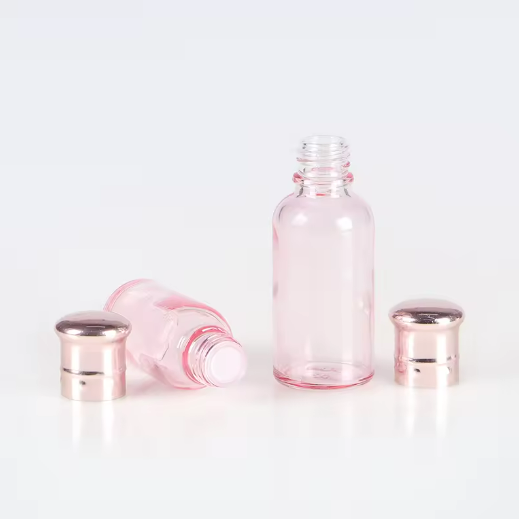 Customized color 30ml 50ml 100ml clear pink essential oil glass bottle with rose golden cap